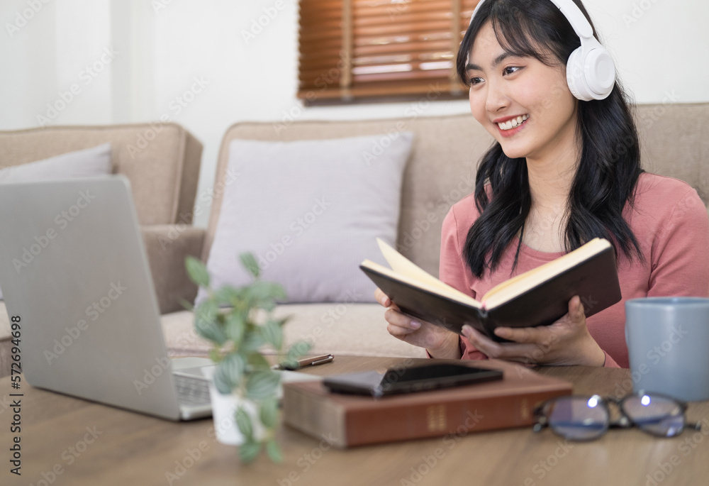 Smiling girl student wear wireless headphone study online with skype teacher, happy young woman learn language listen lecture watch webinar write notes look at laptop sit in cafe, distance education Smiling girl student wear wireless headphone study online with skype teacher, happy young woman learn language listen lecture watch webinar write notes look at laptop sit in cafe, distance education