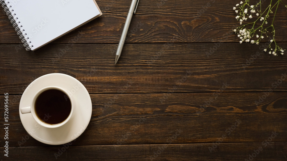 Composition with a clean note, pen, a cup of coffee, and gypsophila flowers on a dark wooden background with a space for text Composition with a clean note, pen, a cup of coffee, and gypsophila flowers on a dark wooden background with a space for text