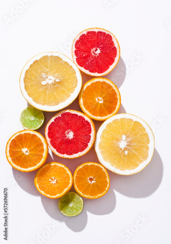 Fresh citrus fruit  oranges  red blood oranges tarocco   pomelo  lime om the white background   sunlight  top view