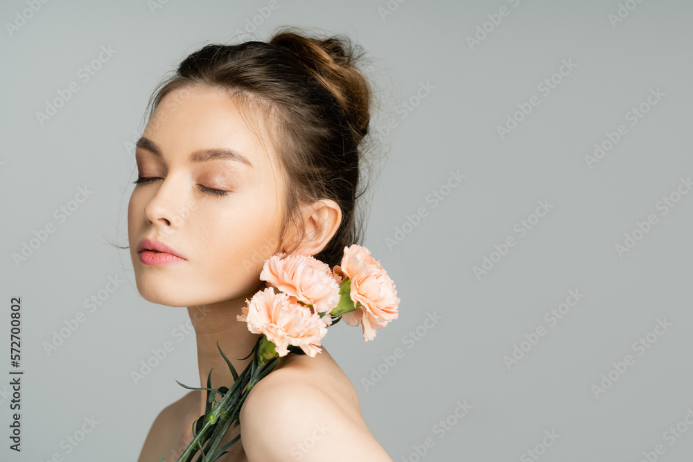 Pretty woman with natural makeup posing with carnations isolated on grey. Pretty woman with natural makeup posing with carnations isolated on grey.