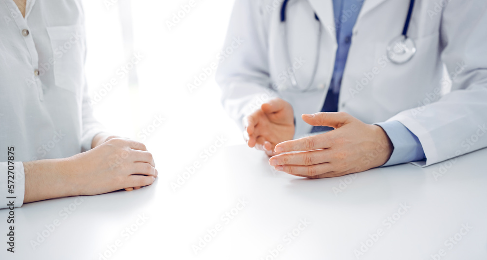 Doctor and patient discussing current health questions while sitting near of each other at the table in clinic, just hands closeup. Medicine concept Doctor and patient discussing current health questions while sitting near of each other at the table in clinic, just hands closeup. Medicine concept