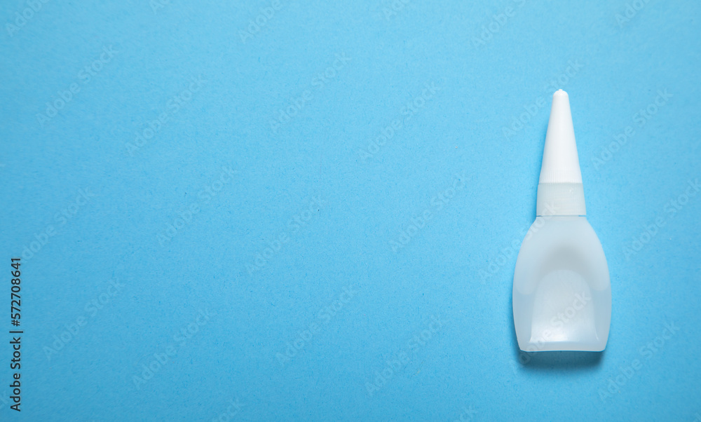 Bottle of glue on the blue background. Bottle of glue on the blue background.