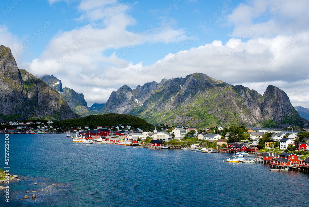 View of a fishing village from a fjord in the Lofoten Islands. Reine. Red Scandinavian houses on the shore of the fjord