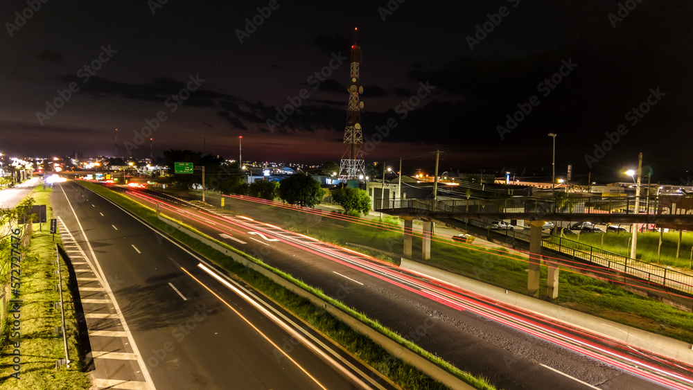 Marilia, Sao Paulo, Brazil, January 26, 2023. traffic on the Highway and silhouette of a telecommunications antenna in Marilia city, during a sunset