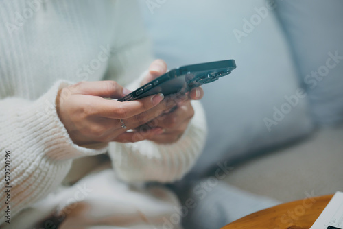 Happy asian woman using mobile phone and receiving good news.on sofa at living room