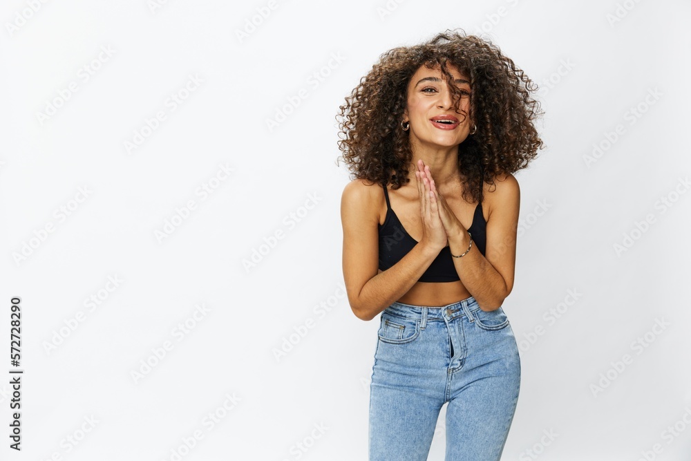 Beautiful woman with curly afro hair posing on a white isolated background smile happiness in jeans and black top emotion, hand signs, copy space Beautiful woman with curly afro hair posing on a white isolated background smile happiness in jeans and black top emotion, hand signs, copy space