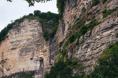 The Kinchkha waterfall in the canyon of the river Okatse. Rest in Georgia. High waterfall in the Imereti region. Rocky ledges of the mountain with green trees. photo