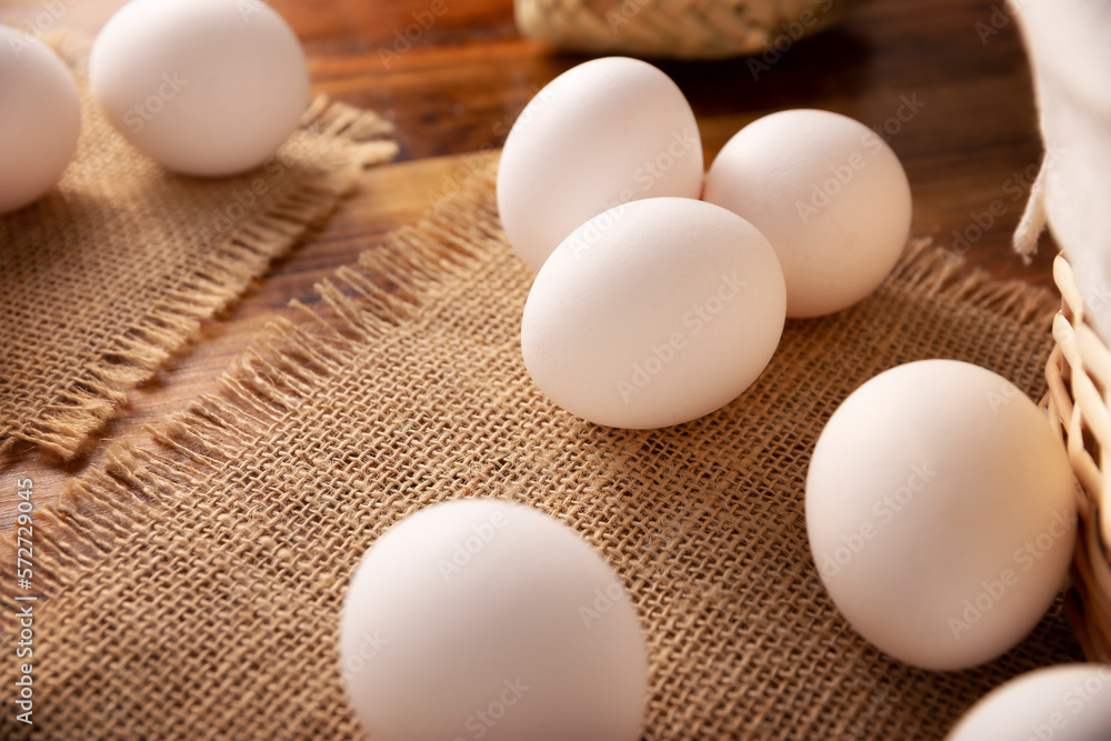 Many white chicken eggs on rustic wooden table. Very popular nutritious and economic food product. Closeup image. Many white chicken eggs on rustic wooden table. Very popular nutritious and economic food product. Closeup image.