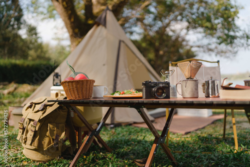 Outdoor Camping Table set with nature beside tent campsite. Travel and camping concept