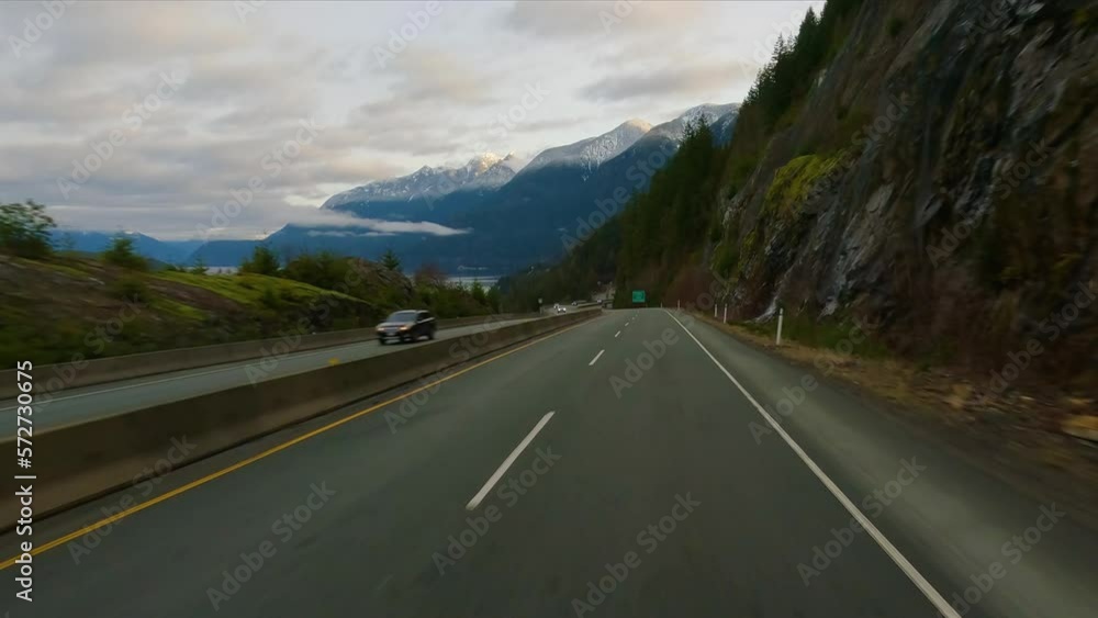 Driving on Sea to Sky Highway between Squamish and Vancouver, BC, Canada. Cloudy Winter Sunrise Sky. Slow Motion Driving on Sea to Sky Highway between Squamish and Vancouver, BC, Canada. Cloudy Winter Sunrise Sky. Slow Motion
