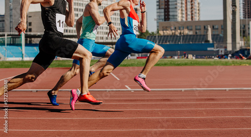Photo men sprinters run on track stadium in athletics competition