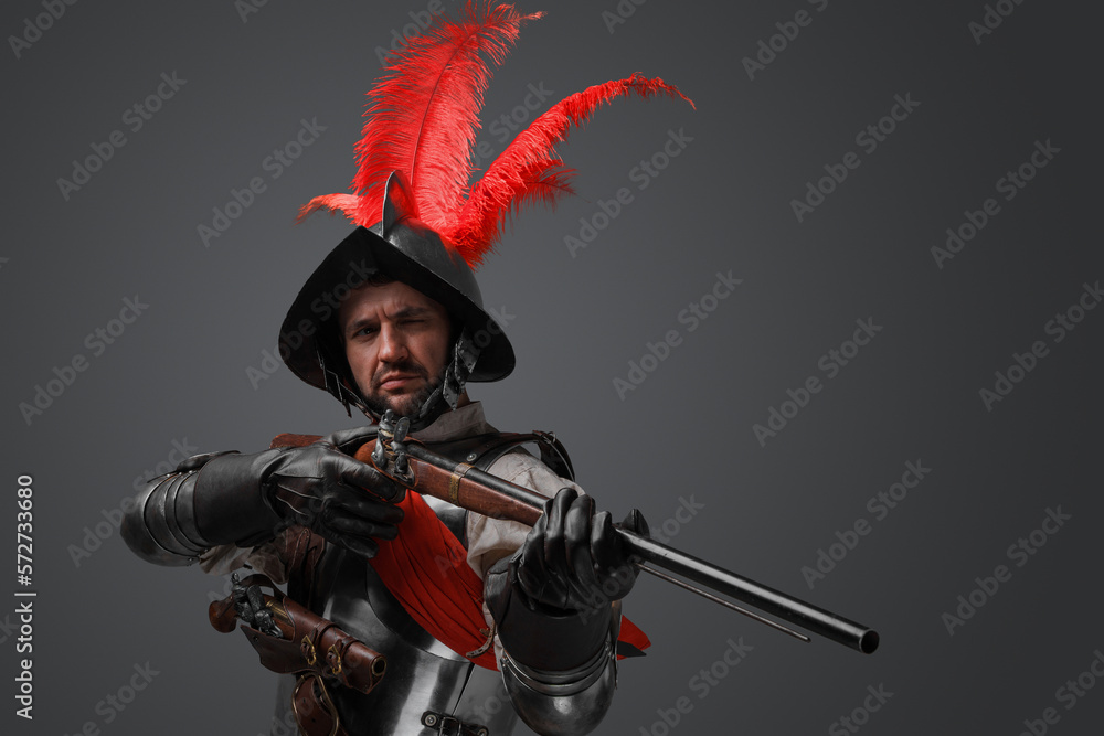 Obraz premium Studio shot of rifleman dressed in plate armor and helmet holding rifle.