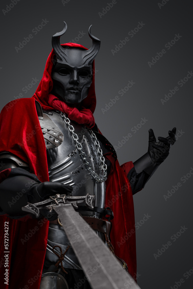 Obraz premium Portrait of evil knight with black mask pointing his sword to camera.