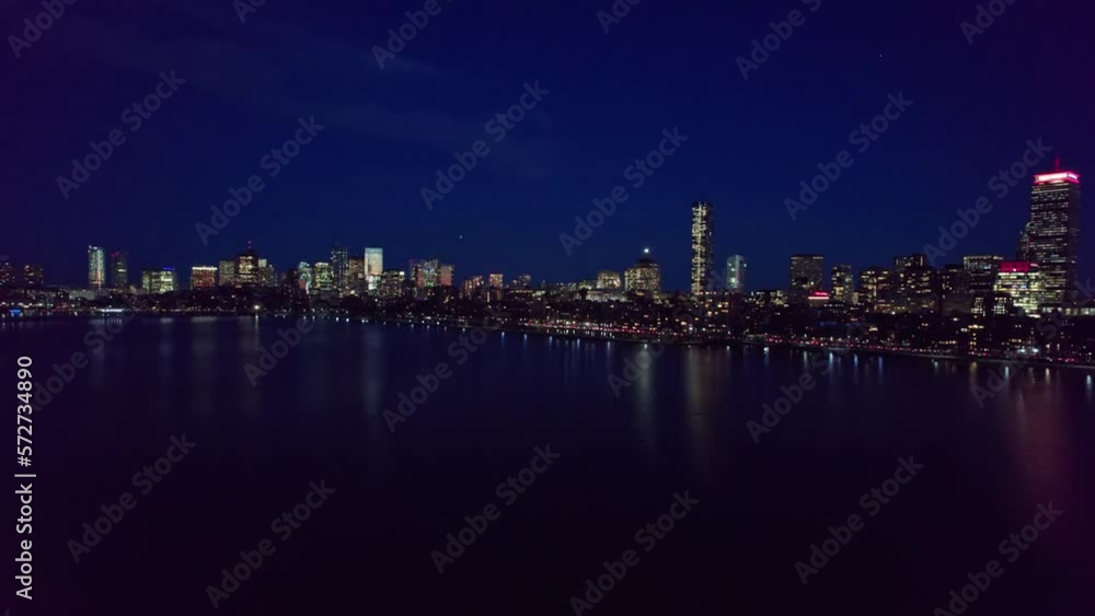 Boston, MA skyscrapers, business traffic, and lights during a blue, dark night from an aerial and establishing drone shot perspective Boston, MA skyscrapers, business traffic, and lights during a blue, dark night from an aerial and establishing drone shot perspective