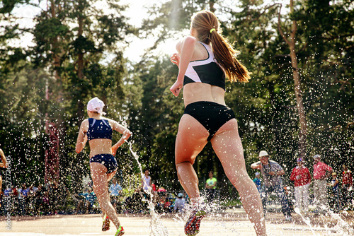 girl athletes runners run steeplechase photo
