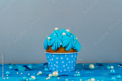 Birthday cupcake with a burning candle, blue background, homemade cakes, ball decorations