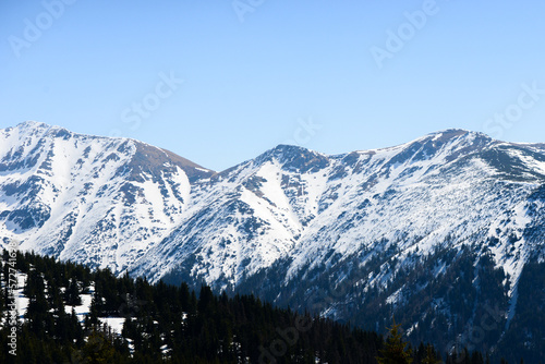 Beautiful view of the snowy mountains with blue sky , no clouds during day in the spring. Spring meadow with snow and knee-timber. West Tatras, Slovakia, Liptovsky Mikulas.