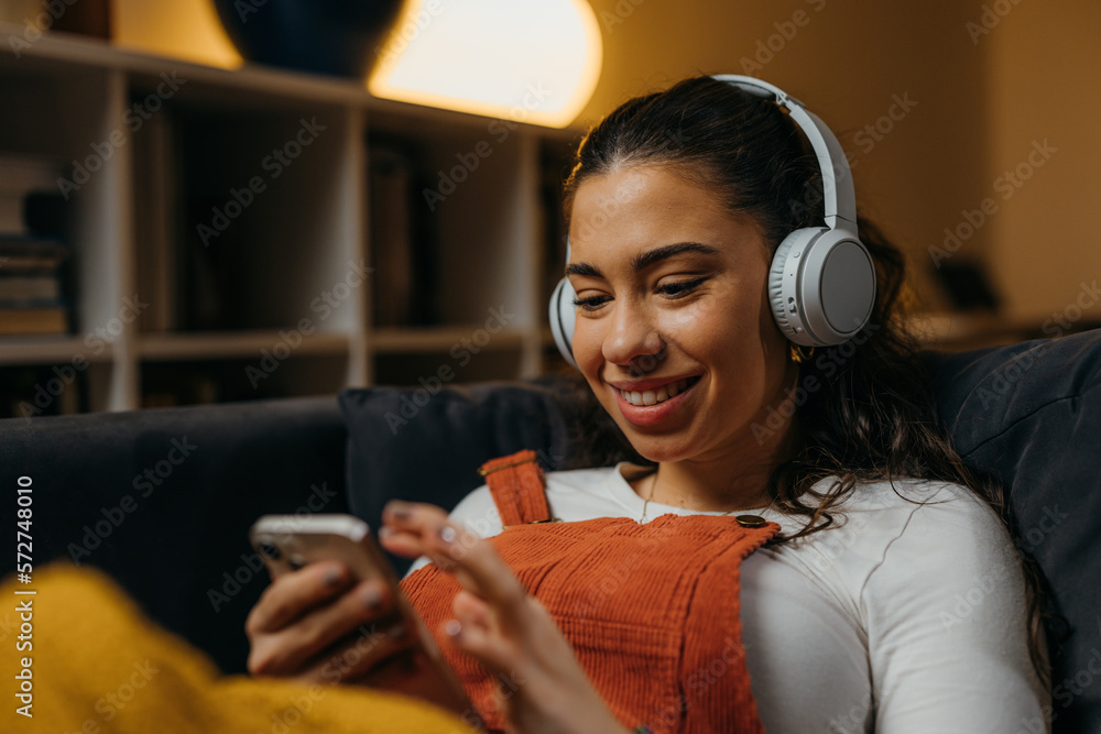 Young caucasian woman relaxes at home with music - obrazy, fototapety, plakaty 