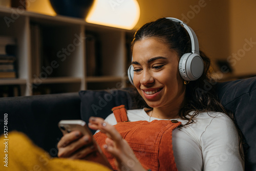 Stampa su tela Young caucasian woman relaxes at home with music