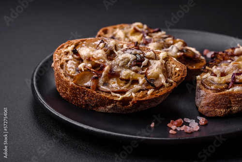 Delicious crispy toast or bruschetta with fried onion, champignon mushrooms and cheese