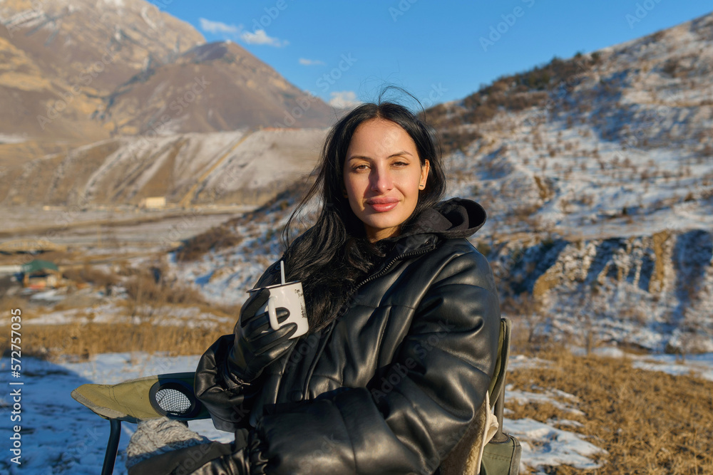 girl drinks tea in winter in the mountains