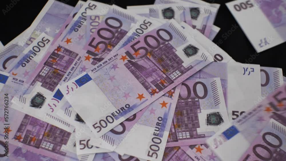 On the bitcoin lying on a black background, euros are pouring in a large stream. A large pile of euro bills is formed on a lying bitcoin. The concept of making money on bitcoin. On the bitcoin lying on a black background, euros are pouring in a large stream. A large pile of euro bills is formed on a lying bitcoin. The concept of making money on bitcoin.
