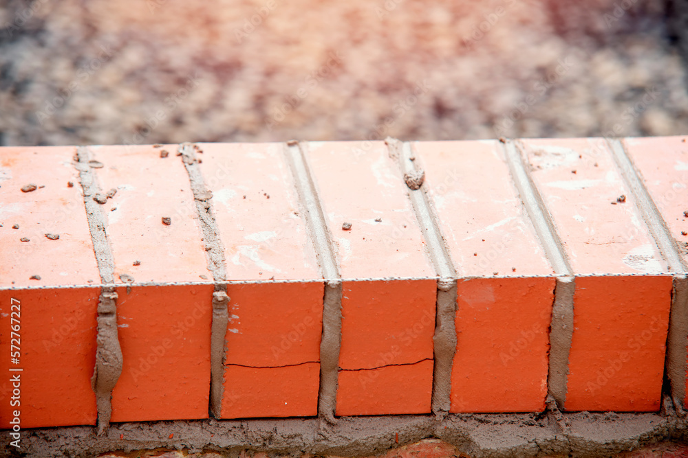 Close up of a brick wall and jointer trowel used by the worker to apply ...
