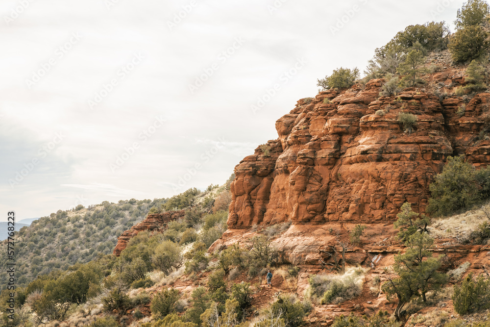 Young female woman walking on popular hiking trail in Sedona Arizona during the day on the famous Airport mesa loop hike near Vortex in Oak Creek area
