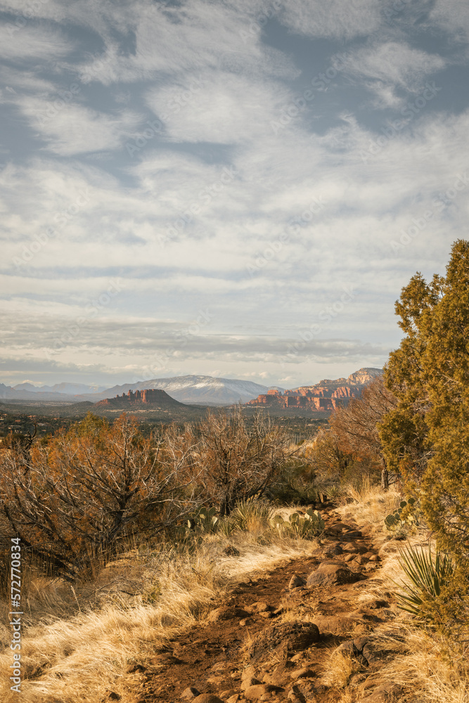 Hiking trail at the popular Airport Mesa loop hike in Sedona Arizona USA southwest during the day with beautiful clouds in the sky looking west.