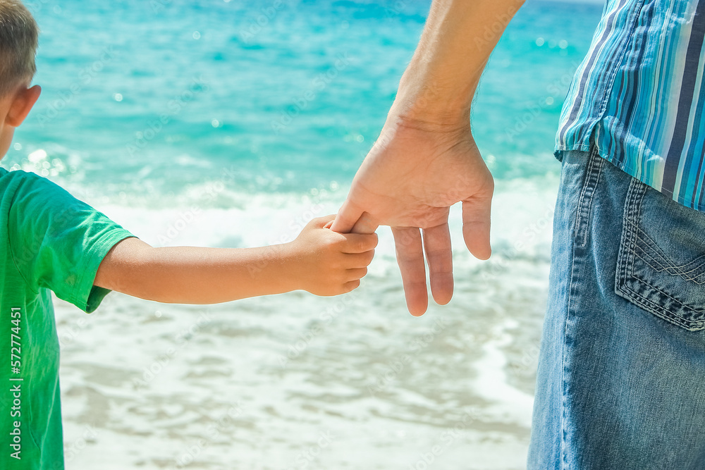 A Hands of a happy parent and child on the seashore on a journey trip in nature A Hands of a happy parent and child on the seashore on a journey trip in nature
