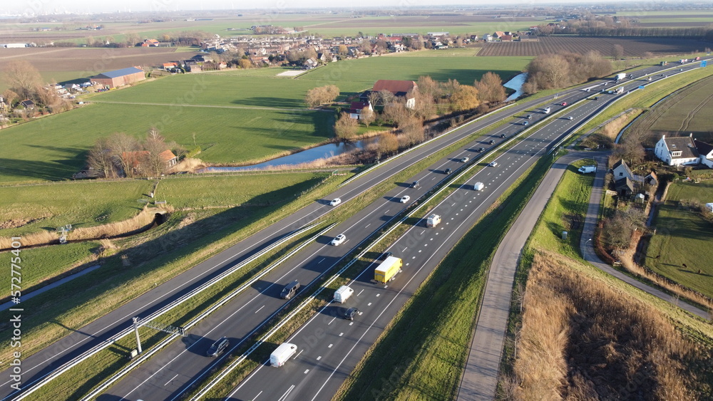 Highway seen from the air in the Netherlands captured with drone. Travel and move, connection with traffic jam and passage with progress. Safety on asphalt with entrance and exit.