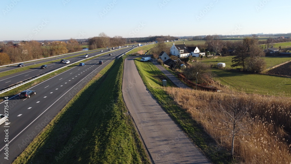 Highway seen from the air in the Netherlands captured with drone. Travel and move, connection with traffic jam and passage with progress. Safety on asphalt with entrance and exit.