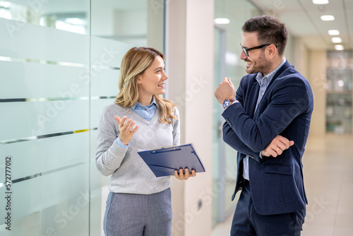 Portrait of beautiful blonde business woman having informal meeting with handsome man in formal-wear at office hall.