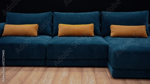 Slow shot in the office towards a dark blue couch with three long yellow pillows. 4k video
