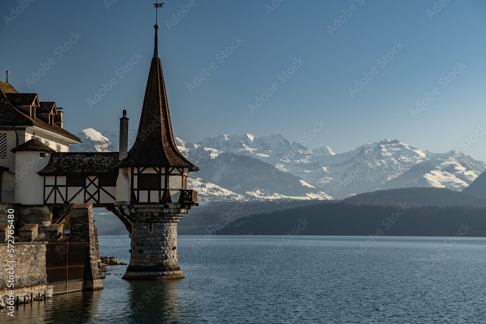 Beautiful little tower of Oberhofen castle in the Thun lake with mountains on background in Switzerland, near Bern
