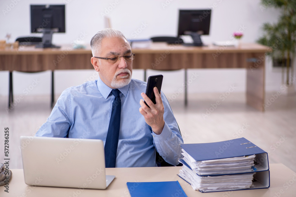 Old male employee working in the office Old male employee working in the office