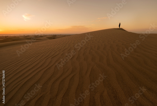 Chico disfrutando del amanecer desde las dunas de Maspalomas en Gran Canaria