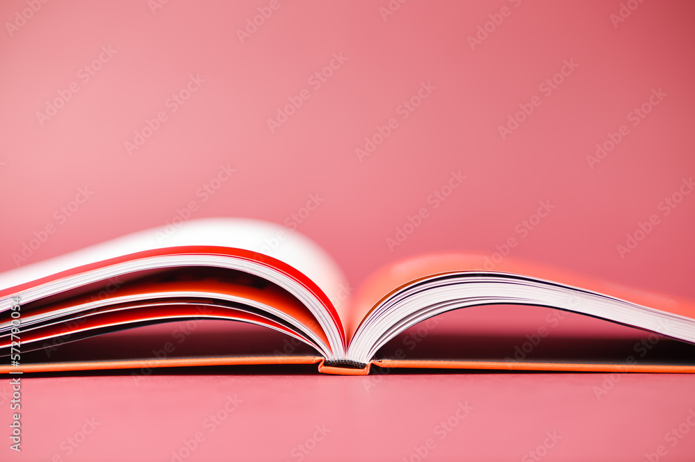 Open orange book on a bright burgundy background Open orange book on a bright burgundy background