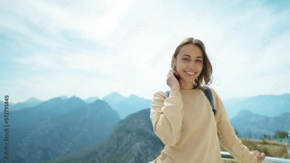 Positive smiling young caucasian woman tourist enjoying breathtaking view at viewpoint among mountains. Adventure and travel exploring Positive smiling young caucasian woman tourist enjoying breathtaking view at viewpoint among mountains. Adventure and travel exploring