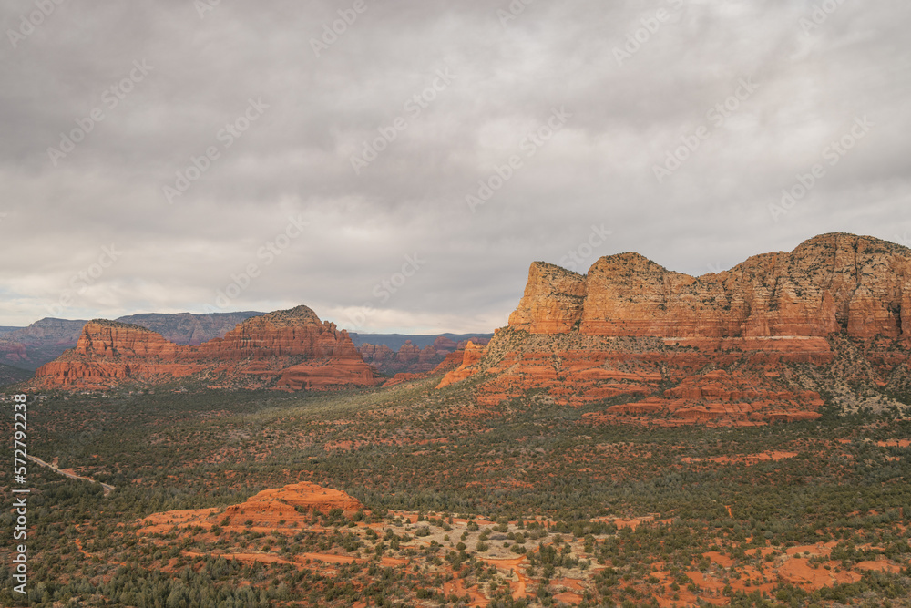 Fototapeta premium Views of red rock buttes and formations within coconino national forest in Sedona Arizona USA against white cloud background. Horizontal Image.