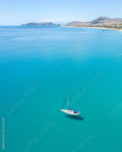 Aerial view of sailing yacht at Porto Santo Island. Shadow under the sea. Clean and clear turquoise water.