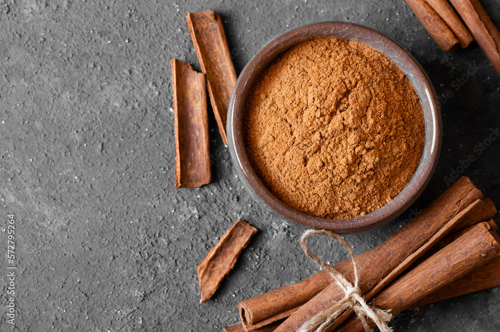 Cinnamon sticks and cinnamon powder on dark rustic background, healthy spice, (Cinnamomum) Cinnamon sticks and cinnamon powder on dark rustic background, healthy spice, (Cinnamomum)