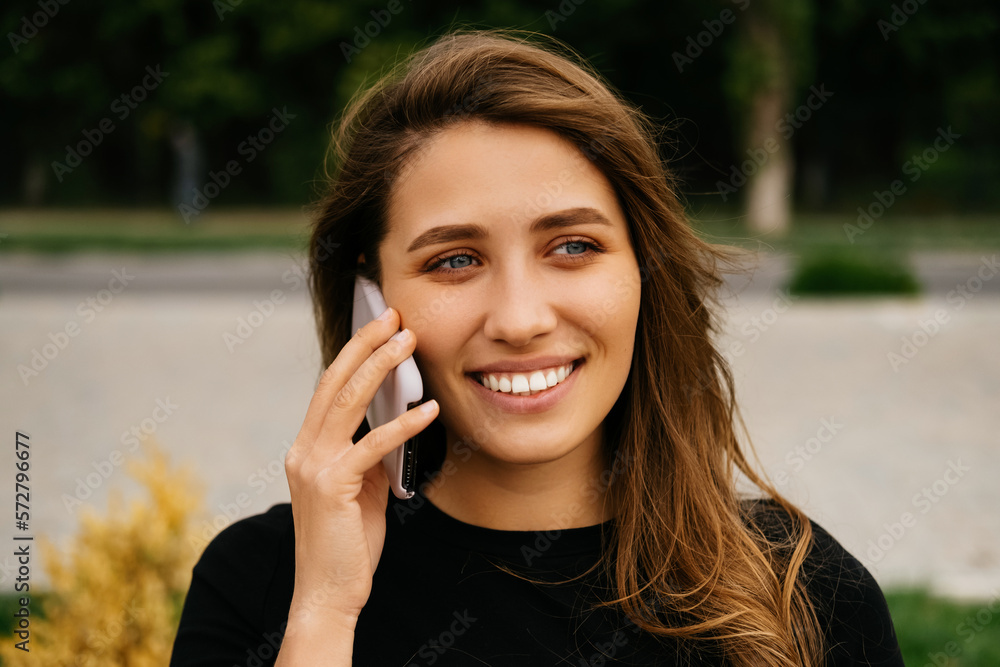 Portrait of a blonde woman having a conversation over the phone outdoors. Portrait of a blonde woman having a conversation over the phone outdoors.
