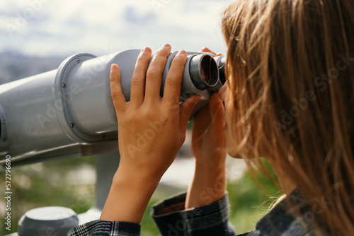 Faceless shot of a blonde woman looking through sight seeing binoculars.