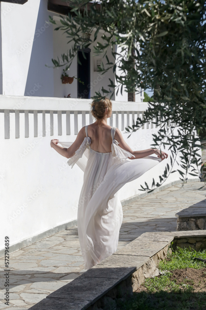Portrait of the bride in long white wedding dress in the tourist resort, destination wedding concept. Island relaxed boho style bridal fashion.