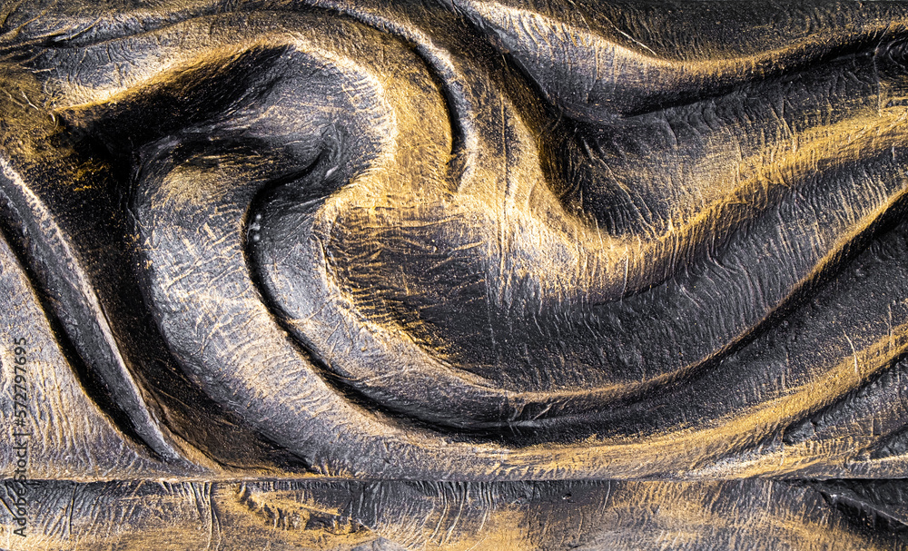 Black and gold painted carved wood swirl design texture Black and gold painted carved wood swirl design texture