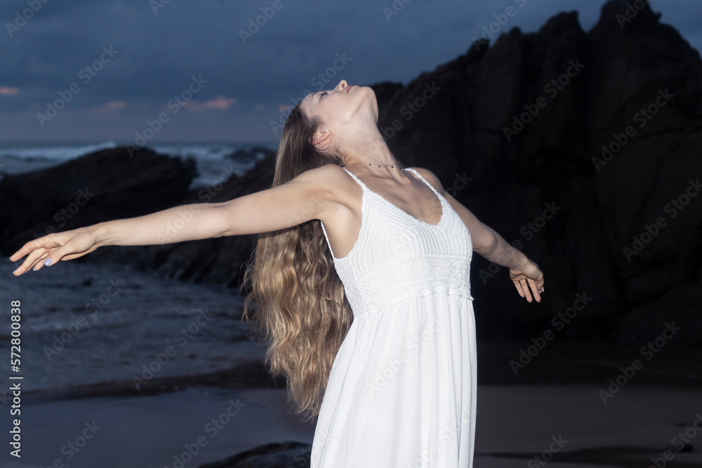 Naklejka premium Free woman raising arms to golden sunset. Freedom and success
