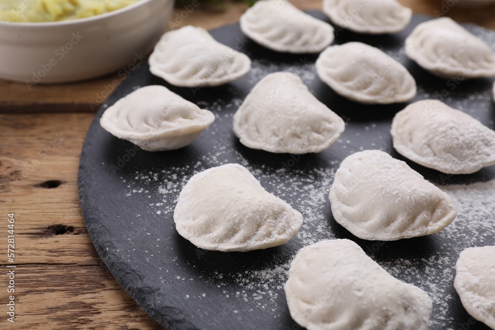 Raw dumplings (varenyky) on wooden table, closeup Raw dumplings (varenyky) on wooden table, closeup