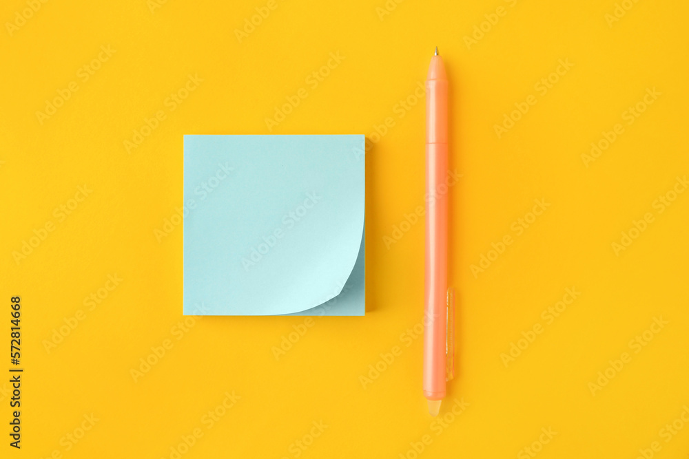 Blank paper note and pen on orange background, flat lay Blank paper note and pen on orange background, flat lay