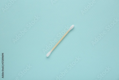 One wooden cotton bud on turquoise background, top view © New Africa